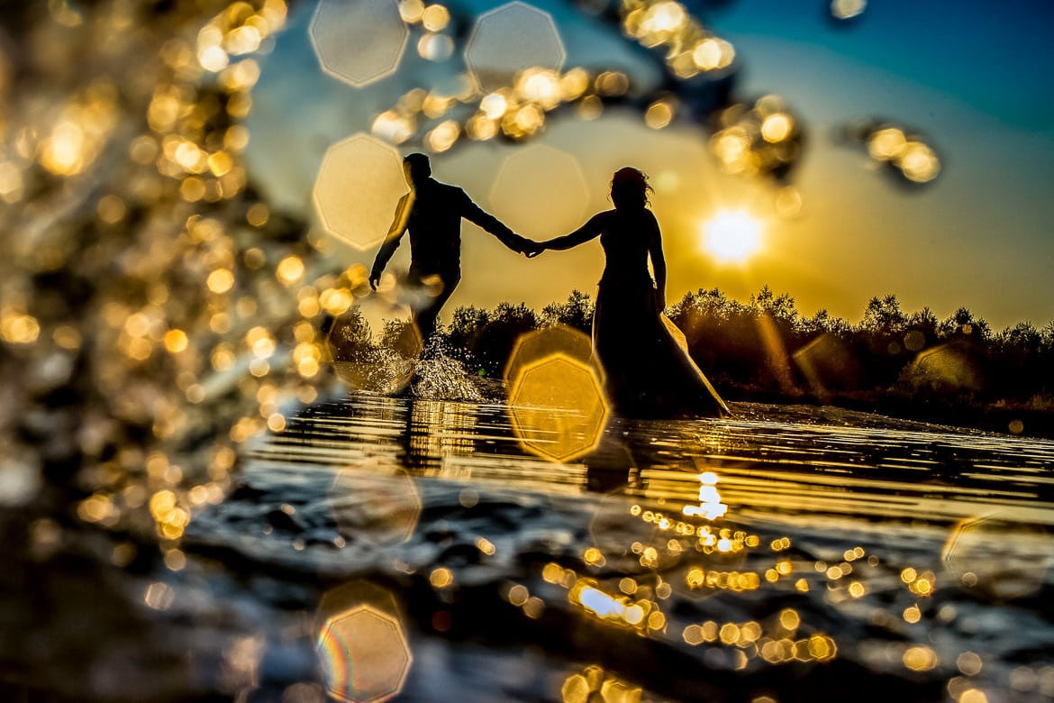 Bruidspaar in het water tijdens sunset