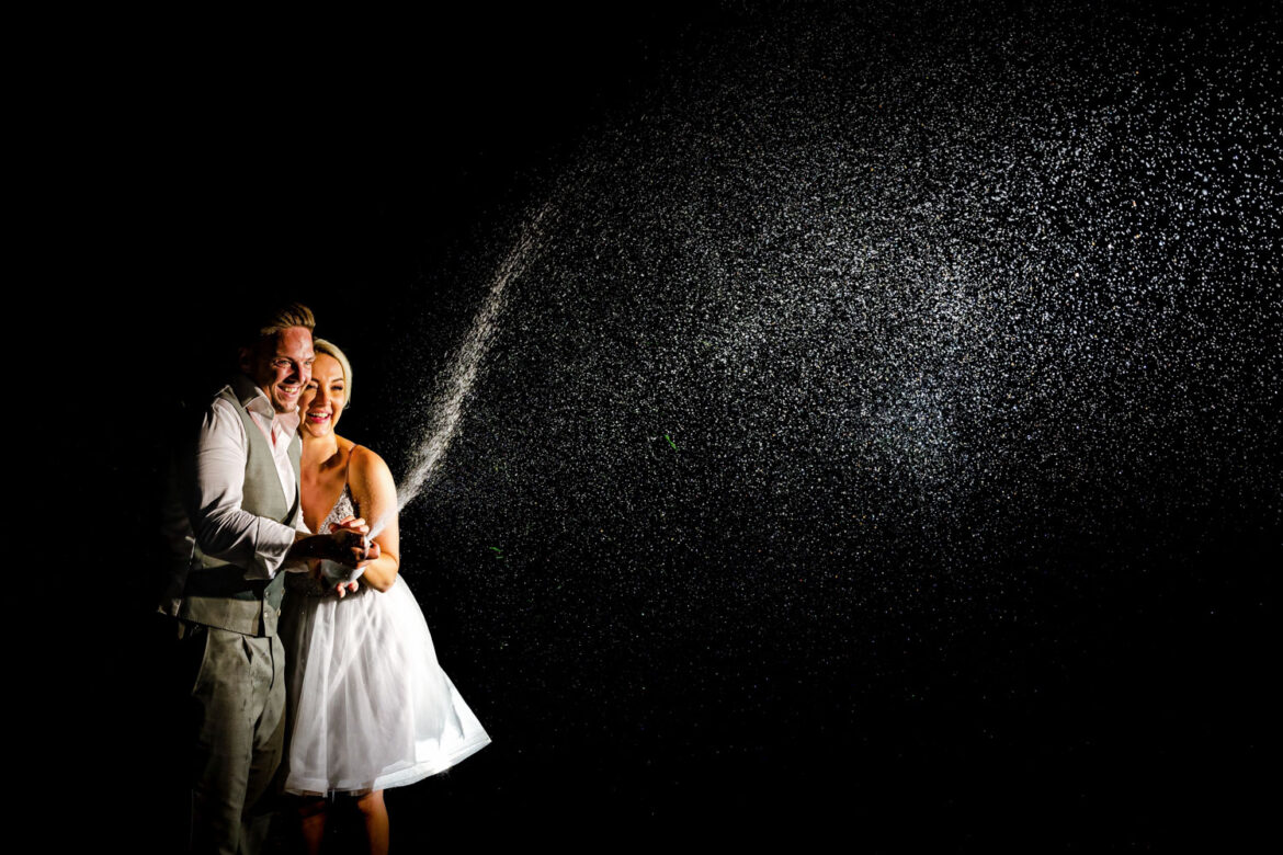 Let's pop the Champagne. Creatieve trouwfoto op het trouwfeest