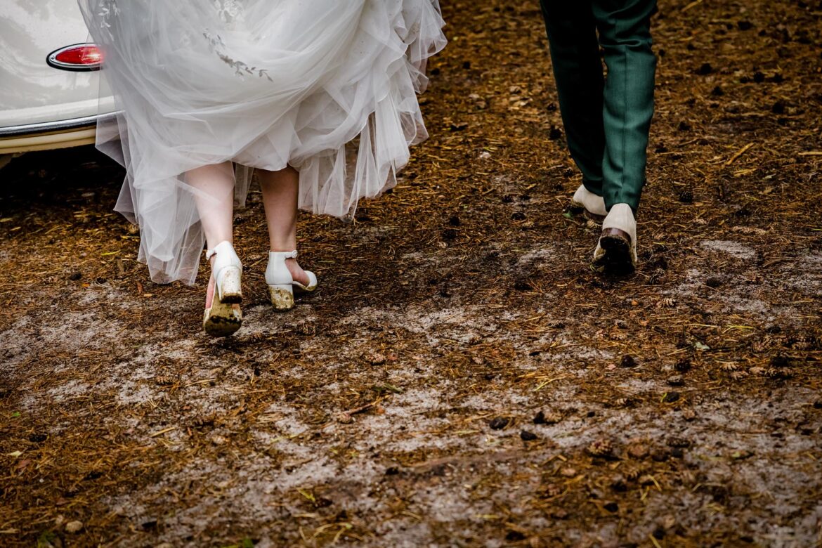 Bruidspaar loopt door de natte paden op de Veluwe