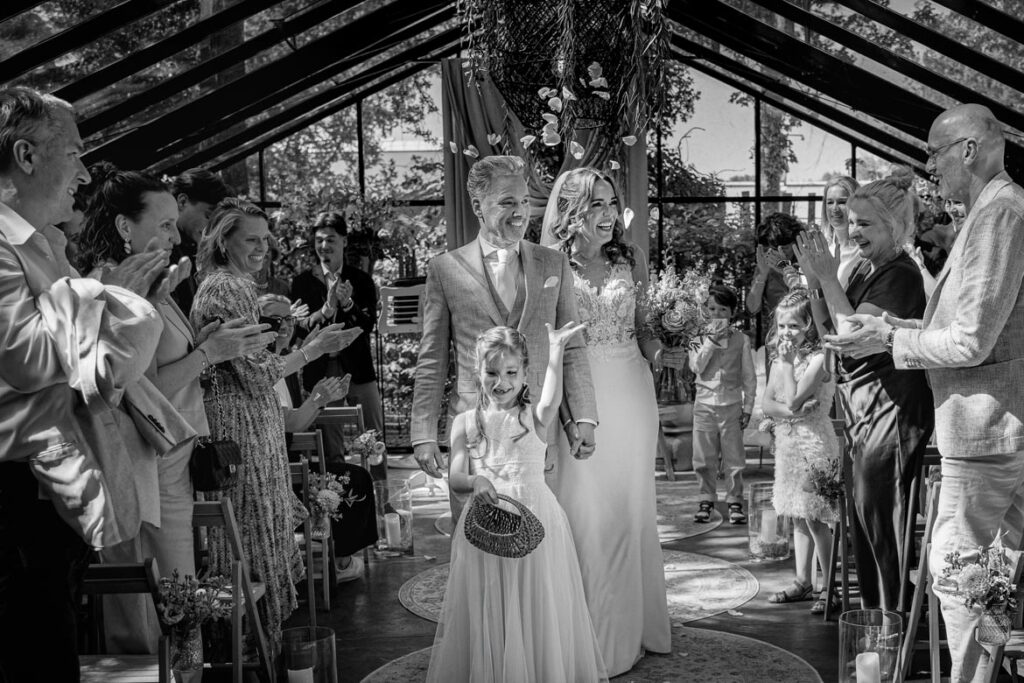 Trouwfotograaf Helmond Brandevoort Eindhoven Geldrop Mierlo Asten of Someren // Trouwdag in Beeld Bruidsfotograaf // Zijn jullie op zoek naar een trouwfotograaf? Trouwen la Serra bij Innesto in Asten. Bruidspaar samen met dochtertje na de ceremonie met rozenblaadjes. Trouwfotograaf bij Innesto in Asten met een trouwreportage die jullie verhaal écht vertelt.